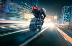 Motorcycle drives through a city at night
