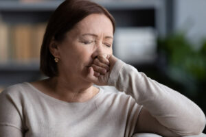 Close up depressed mature woman crying, thinking about health or family problems, sitting on couch alone, frustrated lonely middle aged female lost in thoughts, memories, grieving, bad news